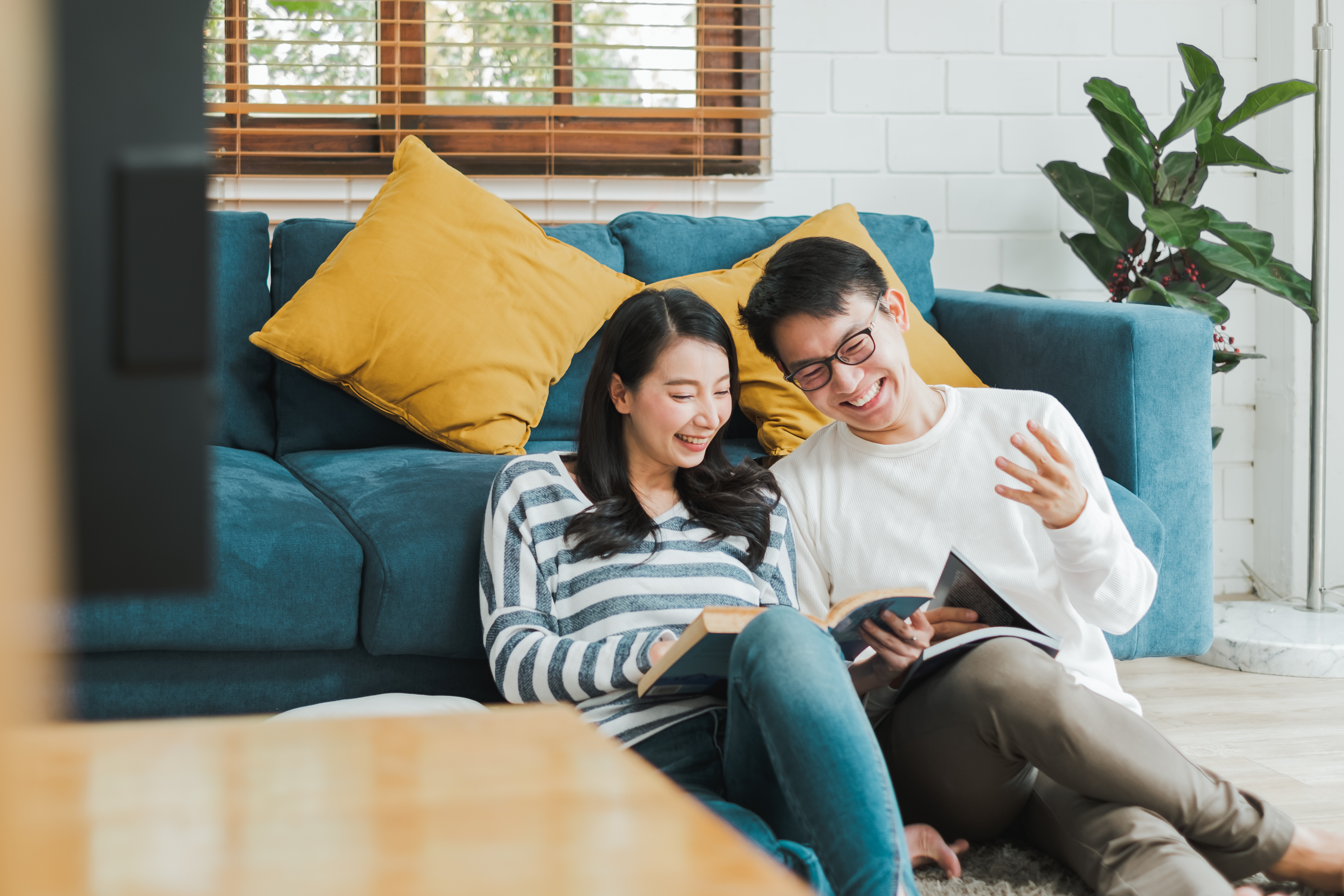 A couple sitting on their living room floor